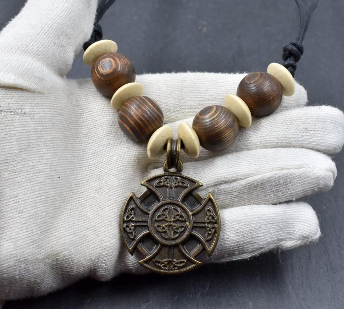 Keltische Holzperlenkette mit Ringkreuz auf der Hand