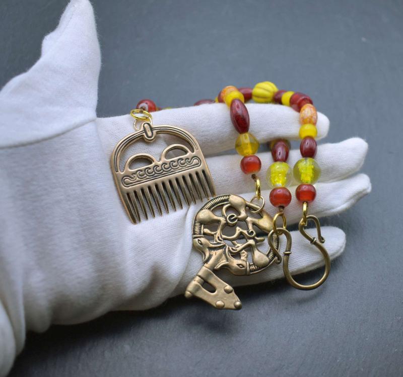 Haithabu Hygiene-Set mit Kamm und Schlüsselan Glasperlenketten in rot und gelb auf Hand