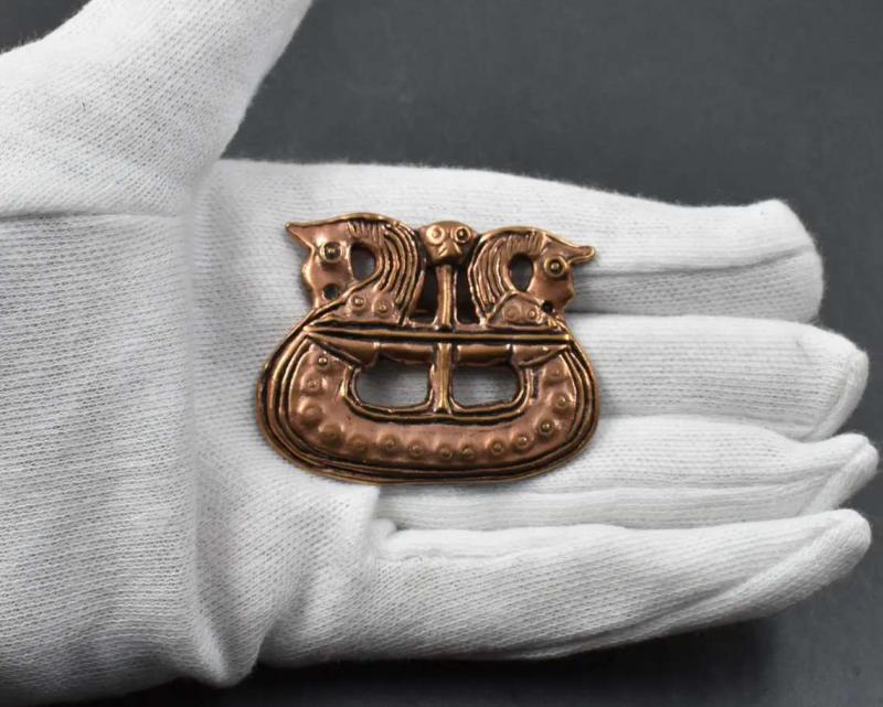 Wikingerschiff als Fibel aus Bronze auf der Hand